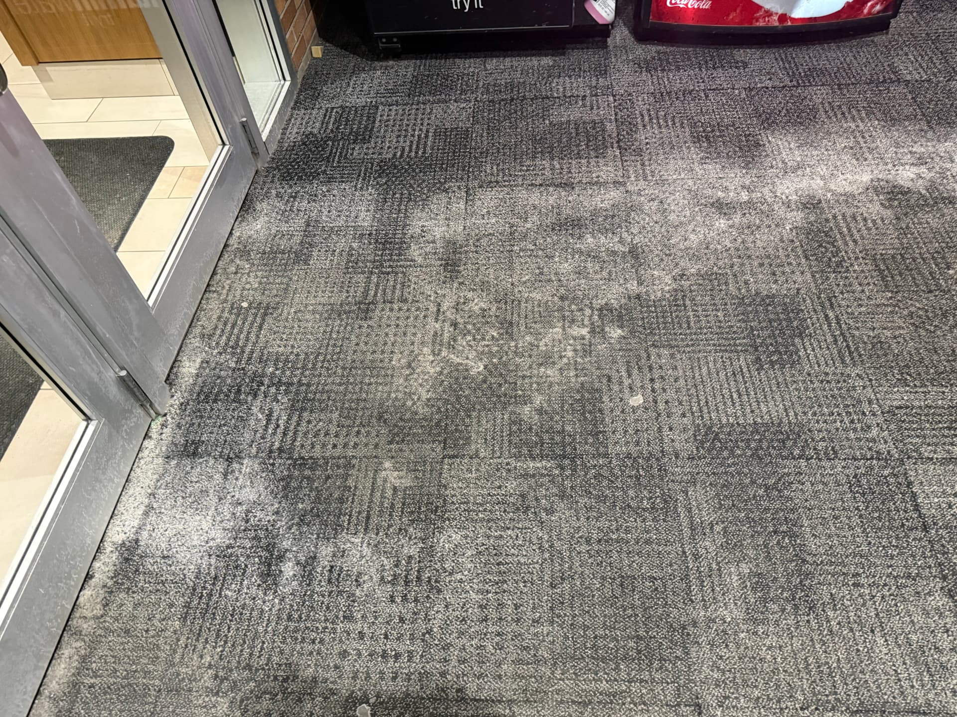 White salt residue ground into carpet near storefront doors, before treatment